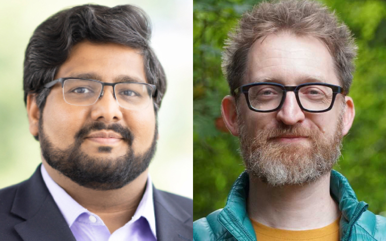Two men side by side. The man on the left, Firas Moosvi, has dark hair and a beard, wearing glasses and a dark suit. The man on the right, Stephan Koenig, has light brown hair and a beard, wearing glasses and a teal jacket, standing outdoors with greenery in the background.